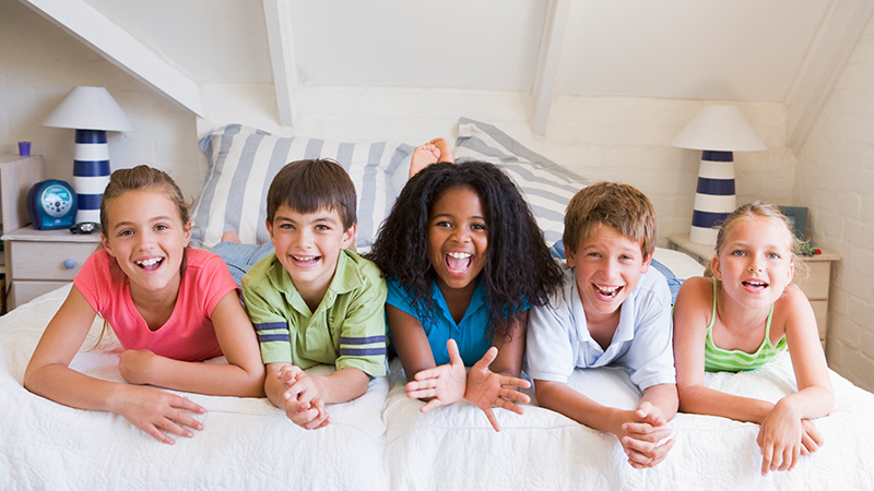 Five Young Friends Lying Down Next To Each Other