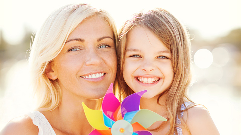 happy mother and child girl with pinwheel toy