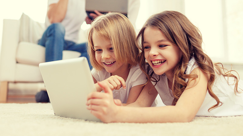 smiling sister with tablet pc and parents on back